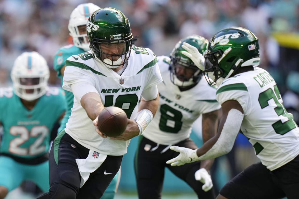 New York Jets quarterback Joe Flacco (19) hands the ball to New York Jets running back Michael Carter (32) during the first half of an NFL football game against the Miami Dolphins, Sunday, Jan. 8, 2023, in Miami Gardens, Fla. (AP Photo/Lynne Sladky)