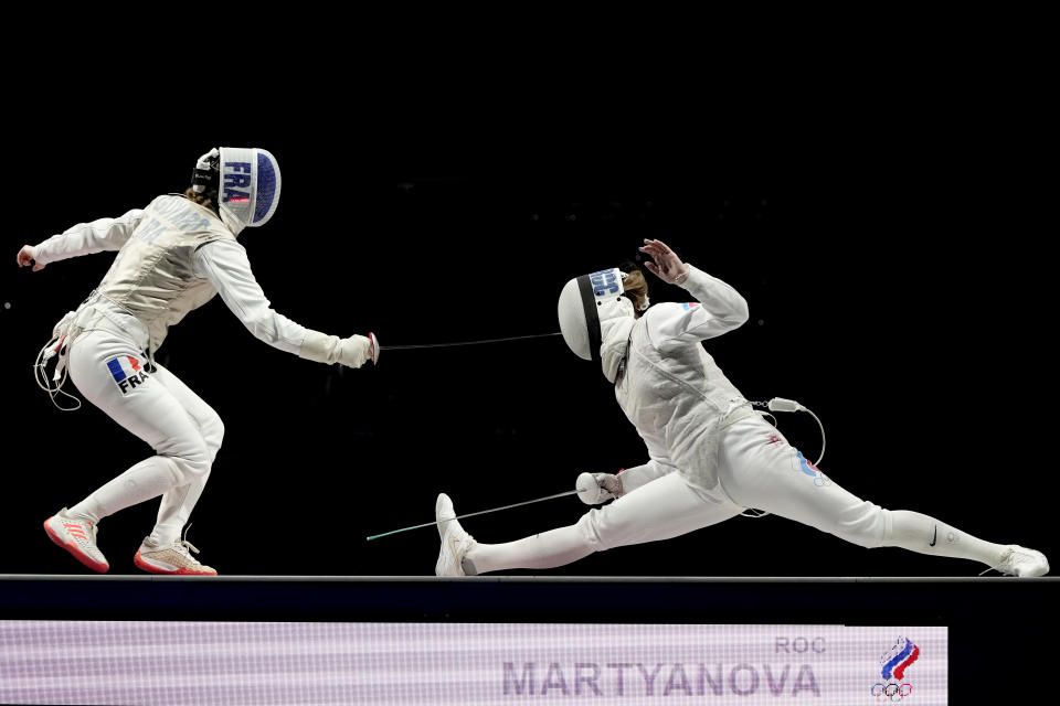 Marta Martyanova of the Russian Olympic Committee, right, and Astrid Guyard of France compete in the women's individual Foil team final medal competition at the 2020 Summer Olympics, Thursday, July 29, 2021, in Chiba, Japan. (AP Photo/Hassan Ammar)