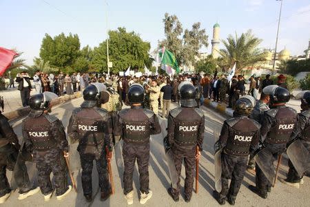 Riot police stand in front of protesters during a demonstration against Turkish military deployment in Iraq, in Najaf, Iraq, December 12, 2015. REUTERS/Alaa Al-Marjani