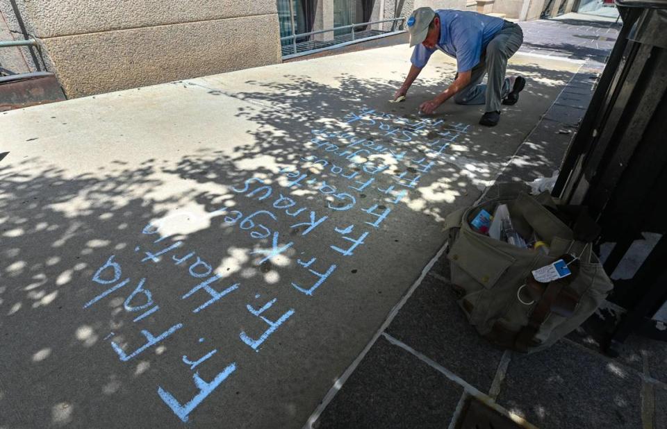 David Clohessy of SNAP, the Survivors Network of those Abused by Priests, wrote the names of priests credibly accused of sexual abuse down Wednesday, June 23, outside the Kansas City-St. Joseph Diocese, 20 W. 9th St., in Kansas City before a sidewalk press conference to denounce that the Diocese has failed to include nearly 20 priests on its list of clergy credibly accused of sex abuse even though they are named elsewhere.