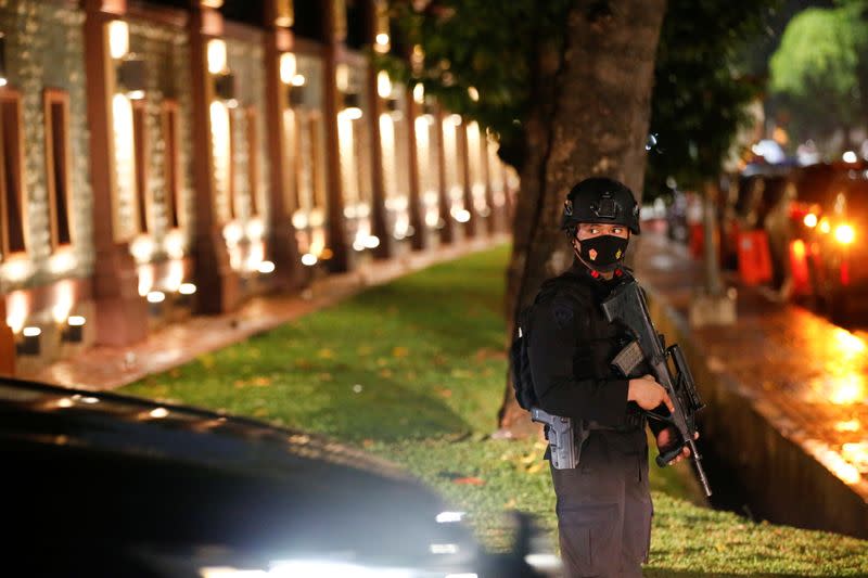 Armed police officer stands guard outside national police headquarters, in Jakarta