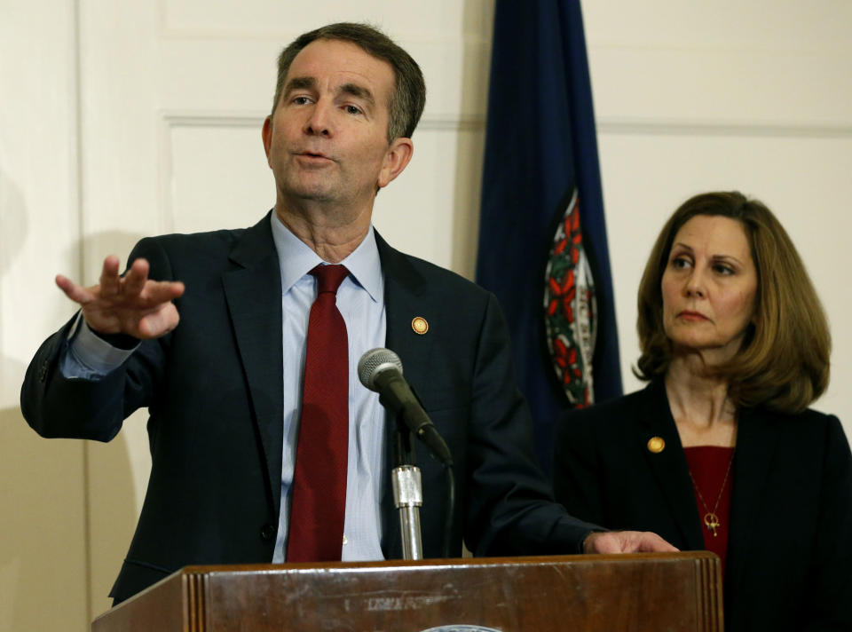 FILE - In this Feb. 2, 2019 file photo, Virginia Gov. Ralph Northam, left, gestures as his wife, Pam, listens during a news conference in the Governors Mansion at the Capitol in Richmond, Va. A law firm has completed its investigation into how a racist photo appeared on a yearbook page for Northam. Eastern Virginia Medical School said in a statement Tuesday, May 21 that the findings of the investigation will be announced at a press conference on Wednesday, May 22. Northam's profile in the 1984 yearbook includes a photo of a man in blackface standing next to someone in Ku Klux Klan clothing. Northam denies being in the photo, which nearly ended his political career in February. (AP Photo/Steve Helber, File)