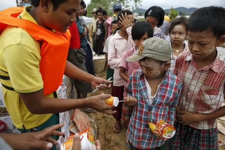 Donors distribute food to student near a flooded village at Kawlin township, Sagaing division, Myanmar July 23, 2015. REUTERS/Soe Zeya Tun/Files