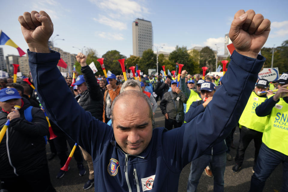A man clenches his fists during a protest outside the government headquarters in Bucharest, Romania, Thursday, Oct. 20, 2022. People joined a protest dubbed "The Anti-Poverty March" demanding salary and pensions increases and government controlled prices for energy and other basic commodities. (AP Photo/Andreea Alexandru)