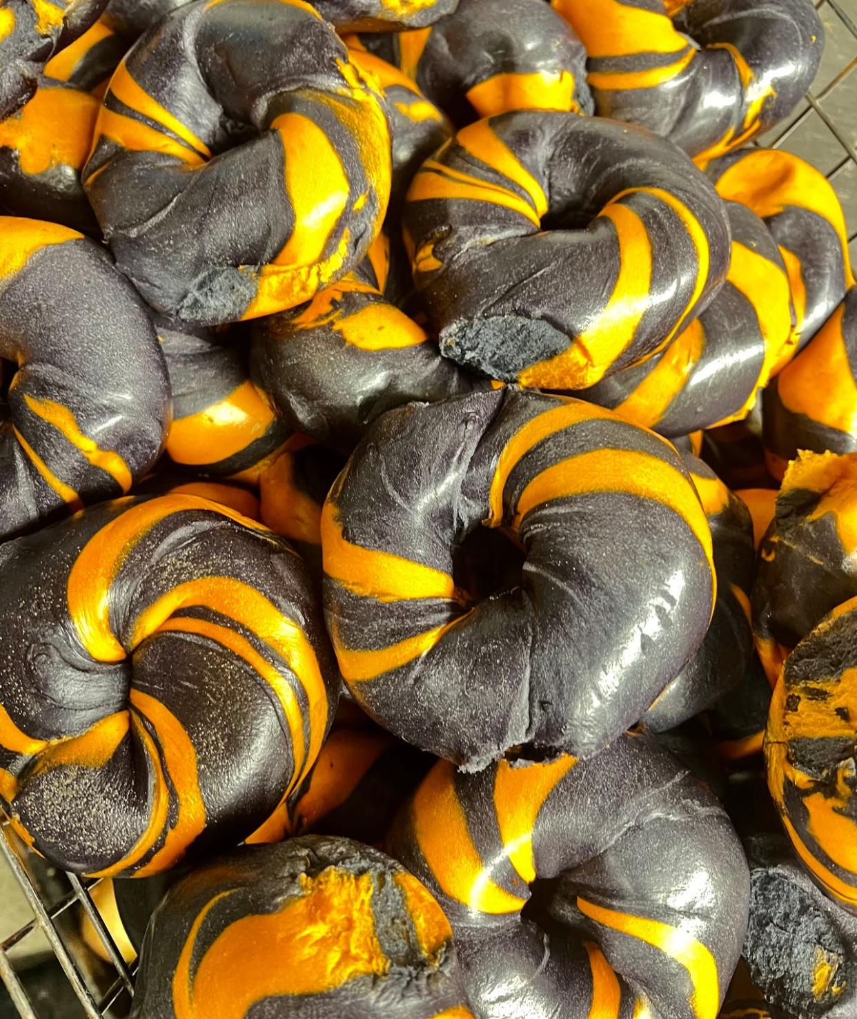 An orange and black, hand-rolled Halloween special bagel from Bagel Nook locations.