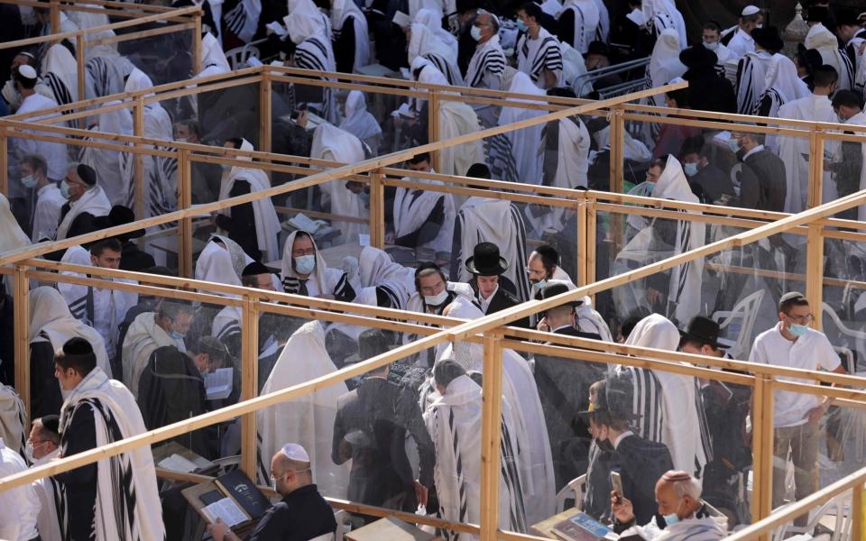 Jewish worshippers pray in large separated cubicles near the Western Wall during the Priestly Blessing on the holiday of Passover, in Jerusalem - EMMANUEL DUNAND /AFP