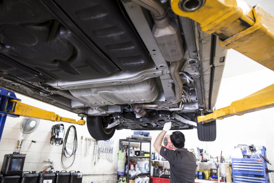 Mechanic working on a car in a garage. (Source: Getty)