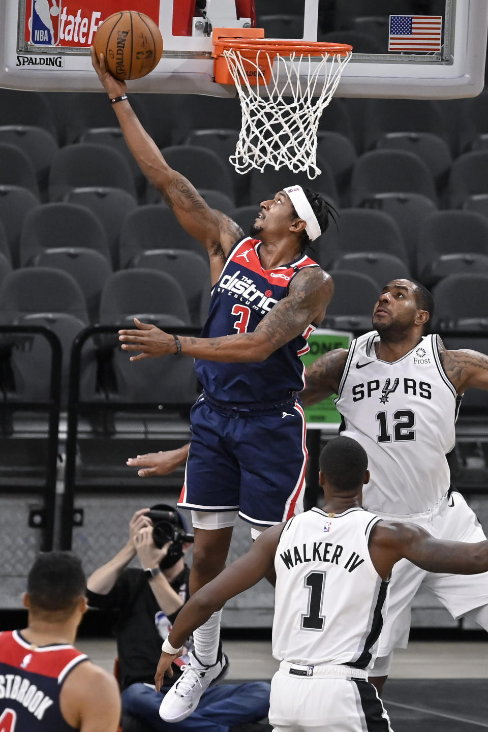 Washington Wizards' Bradley Beal (3) shoots against San Antonio Spurs' LaMarcus Aldridge (12) and Lonnie Walker IV during the first half of an NBA basketball game, Sunday, Jan. 24, 2021, in San Antonio. (AP Photo/Darren Abate)