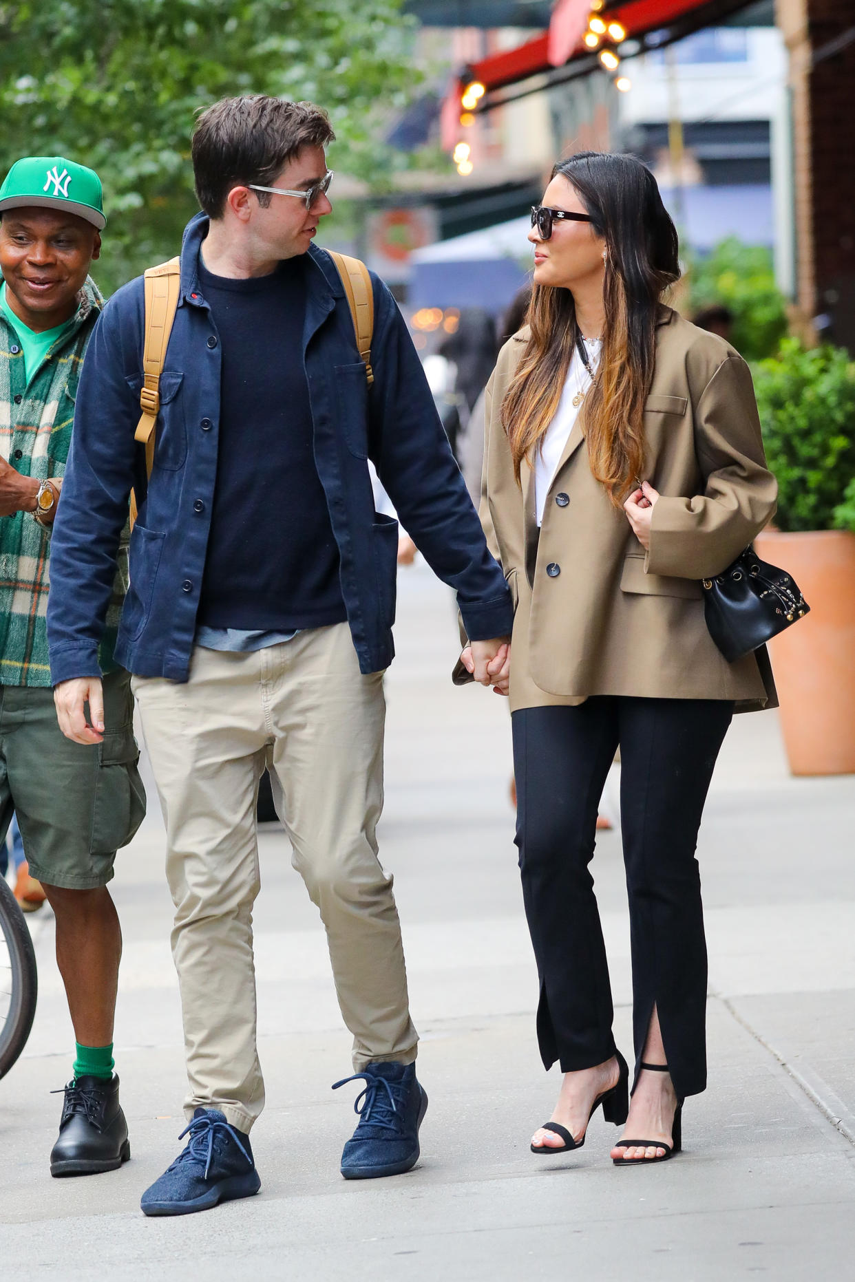 Olivia Munn and John Mulaney holding hands on a New York City street