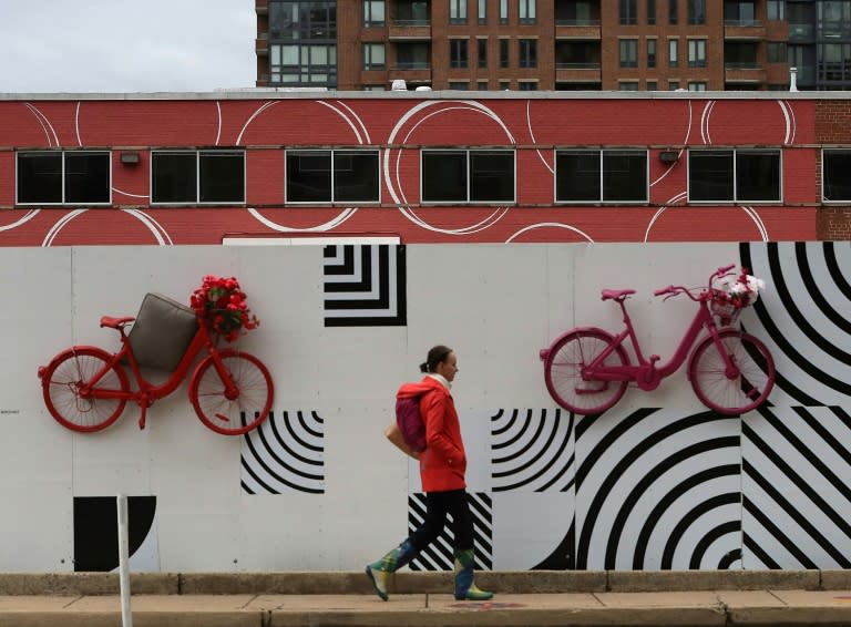 A woman walks outside a building in the Pentagon City neighborhood of Arlington, Virginia, that will make up part of the new Amazon "HQ2" headquarters