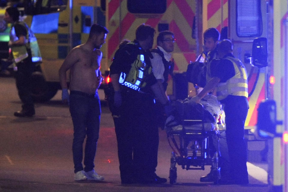 <p>Police officers and members of the emergency services attend to a person injured at the scene of an apparent terror attack on London Bridge in central London on June 3, 2017.<br> Armed police fired shots after reports of stabbings and a van hitting pedestrians on London Bridge on Saturday in an incident reminiscent of a terror attack in March just days ahead of a general election. (Daniel Sorabji/AFP/Getty Images) </p>