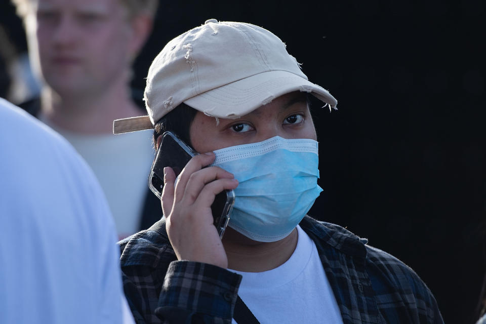 An Asian man wearing a face mask attends the lantern festival part of the Chinese New Year celebrations on the waterfront in Wellington on February 14, 2020. - With tourist numbers from China down because of the Coronavirus outbreak, fewer Chinese are visiting New Zealand and the Pacific. (Photo by Marty MELVILLE / AFP) (Photo by MARTY MELVILLE/AFP via Getty Images)