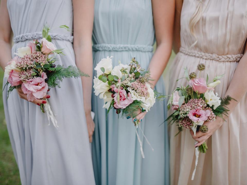 Bridesmaids holding floral bouquets.