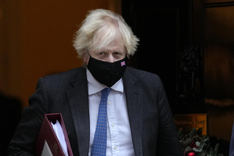 Britain's Prime Minister Boris Johnson leaves 10 Downing Street to attend the weekly Prime Minister's Questions at the Houses of Parliament, in London, Wednesday, Dec. 15, 2021. British lawmakers have voted to approve new restrictions to curb the spread of the omicron coronavirus variant. The House of Commons approved measures ordering masks to be worn indoors in England and requiring proof of vaccination or a negative test to enter nightclubs and large crowded events. (AP Photo/Kirsty Wigglesworth)