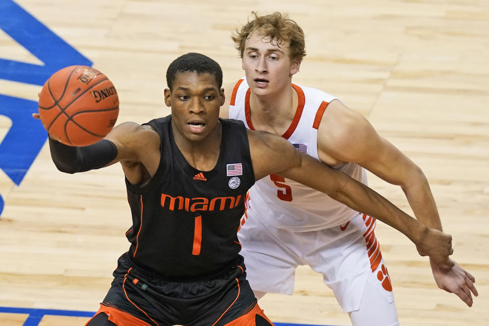 Miami forward Anthony Walker (1) looks for help as Clemson forward Hunter Tyson (5) defends during the second half of an NCAA college basketball game in the second round of the Atlantic Coast Conference tournament in Greensboro, N.C., Wednesday, March 10, 2021. (AP Photo/Gerry Broome)