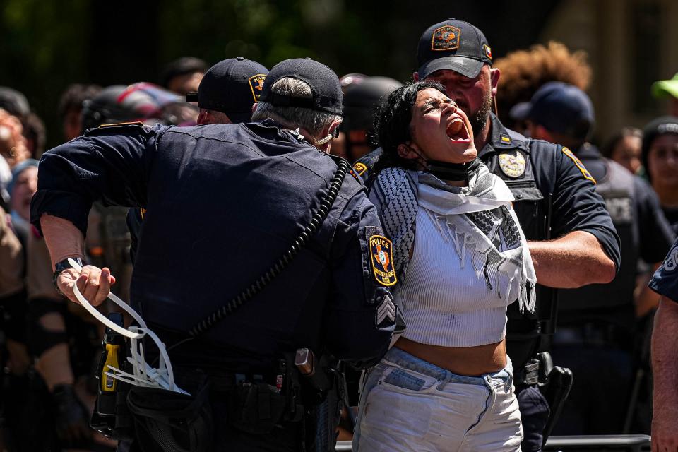 A protester yells "Free Palestine," as she is handcuffed by University of Texas police during a demonstration Monday.