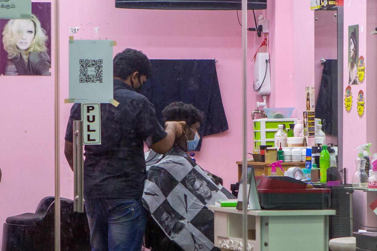  A man in a face mask seen getting a haircut at a barbershop in Little India. (PHOTO: Dhany Osman / Yahoo News Singapore)