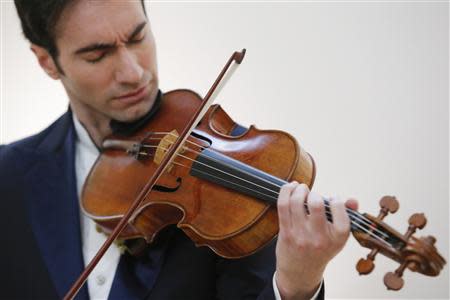 Violist David Aaron Carpenter of the U.S. plays the 'Macdonald' Viola by Antonio Stradivari, made in 1719, at Sotheby's gallery in New York March 27, 2014. REUTERS/Eduardo Munoz