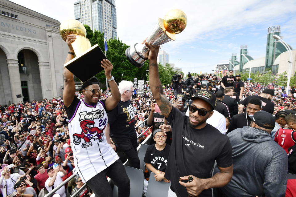 Toronto Raptors guard Kyle Lowry, left, holds the Larry O'Brien Championship Trophy as forward Kawhi Leonard holds his playoffs MVP trophy during the NBA basketball championship team's victory parade in Toronto, Monday, June 17, 2019. (Photo by Frank Gunn/The Canadian Press via AP)