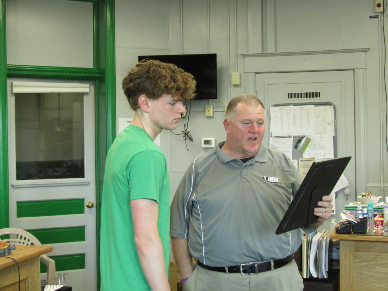 Wethersfield High School Athletic Director Jeff Parsons reads a framed resolution which was presented to All-State swimmer Colton Mosley by the board of education at the opening of its May meeting.