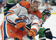 Edmonton Oilers centre Connor McDavid (97) fights for control of the puck with Vancouver Canucks defenseman Quinn Hughes (43) during the first period of an NHL hockey game Thursday, Feb. 25, 2021, in Vancouver, British Columbia. (Jonathan Hayward/The Canadian Press via AP)