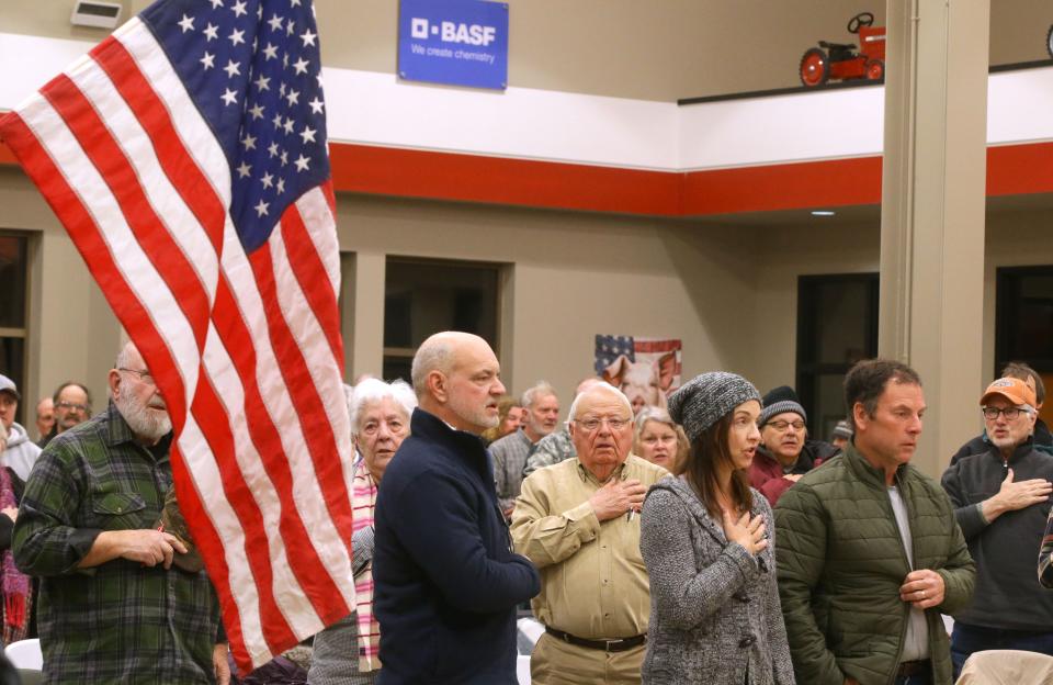 Caucusgoers say the Pledge of Allegiance at the beginning of the meeting Monday, Jan. 15, 2024 at Stutsman agricultural products in Hills, Iowa.