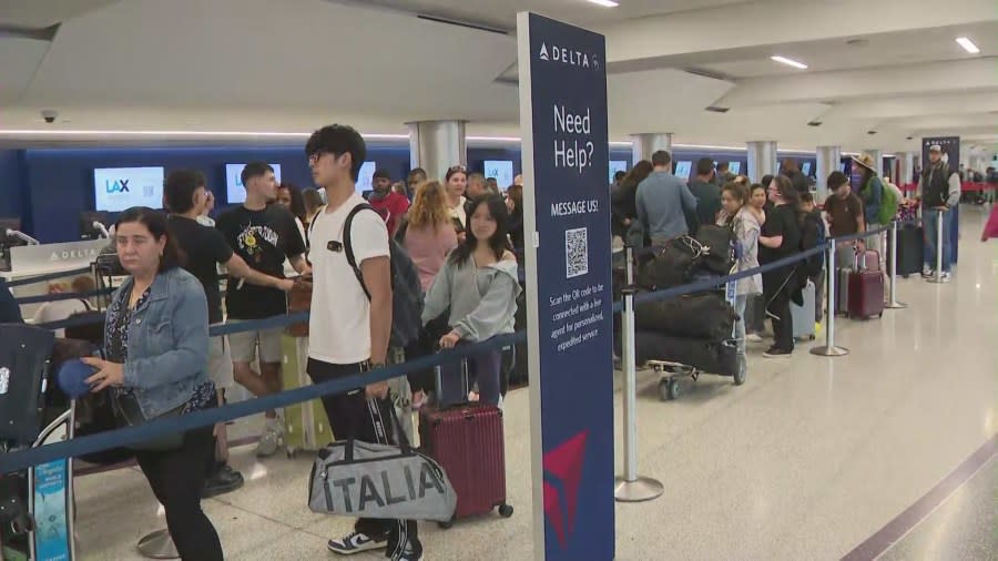 Passengers wait in line at the Delta terminal at LAX on July 23, 2024.