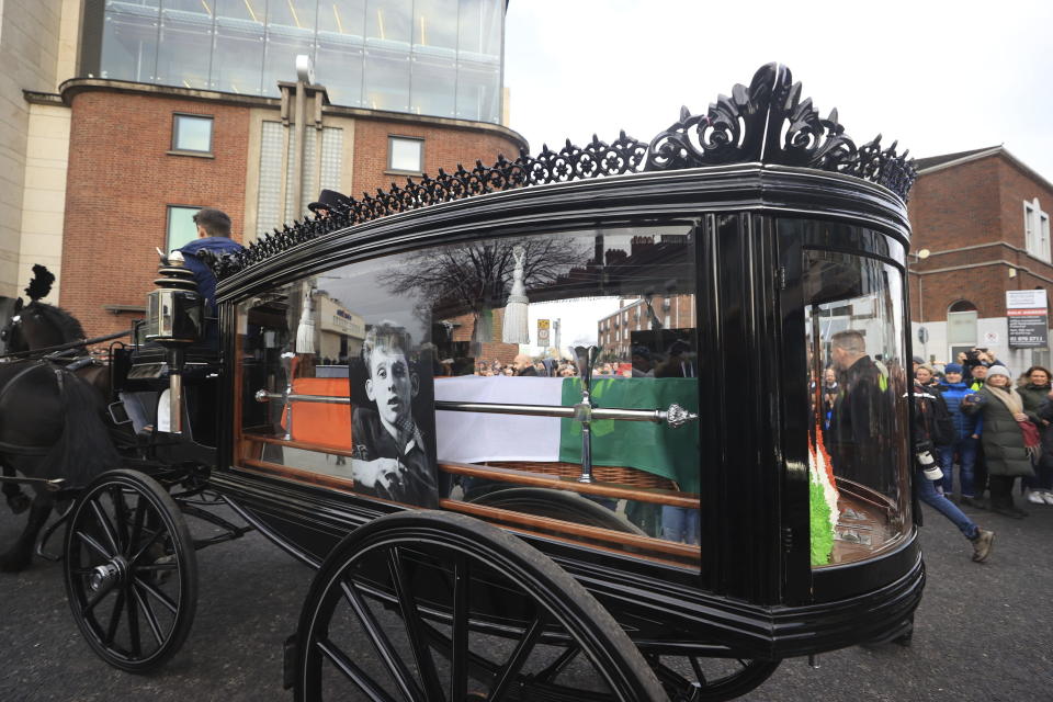 The funeral procession of Shane MacGowan starts from outside Shelbourne Park Stadium as it makes its way through the streets of Dublin, ahead of his funeral in Co Tipperary, in Ireland, Friday, Dec. 8, 2023. MacGowan, the singer-songwriter and frontman of The Pogues, best known for their ballad “Fairytale of New York,” died on Thursday, Nov. 30, 2023. He was 65. (Liam McBurney/PA via AP)