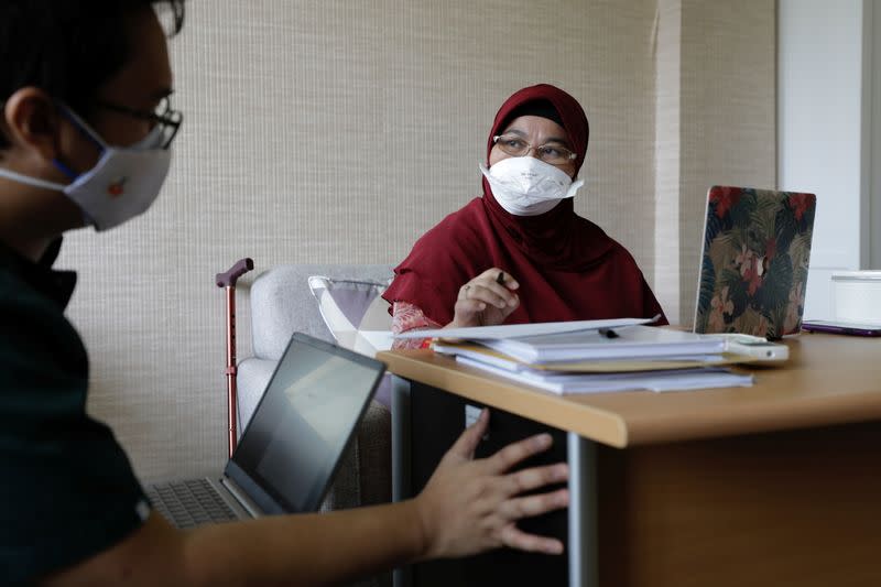 Dr Erlina Burhan, a pulmonologist and Head of Operational Workgroup for COVID-19 Management of the Persahabatan Hospital discusses with a 25-year-old Junior Doctor Frisky Maulida, at her room in Jakarta