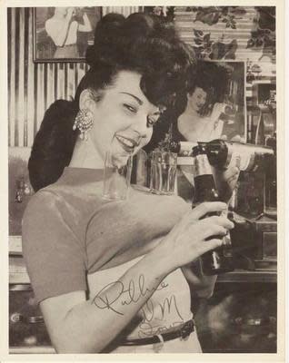 An undated file photo showing Ruthie Bisignano, a Des Moines bar owner who earned notoriety in the 1950s for pouring and serving beers balanced on her chest, demonstrating her signature trick.