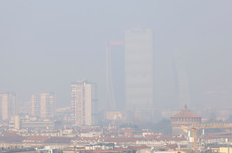 Vista general de edificios de gran altura cubiertos en smog en Milán, Italia