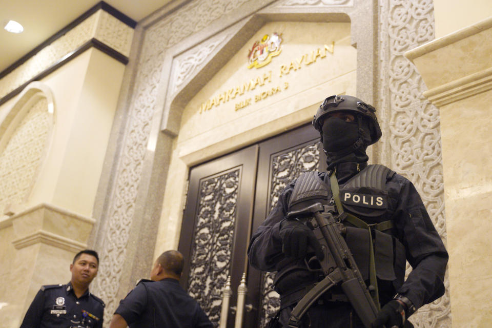 Police stand in front of a court room at the Court of Appeal in Putrajaya, Malaysia, Thursday, Jan. 24, 2019. Indonesian woman Siti Aisyah jointly accused of murdering Kim Jong Nam, the estranged half-brother of North Korea's leader, won an appeal to obtain witness statements given to police as part of her defense. But prosecutors say they will challenge the court's ruling in the nation's top court. (AP Photo/Yam G-Jun)