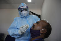 An Indian health worker takes a nasal swab sample of roadside vendor at a health center in Ahmedabad, India, Wednesday, July 8, 2020. India has overtaken Russia to become the third worst-affected nation by the coronavirus pandemic. (AP Photo/Ajit Solanki)