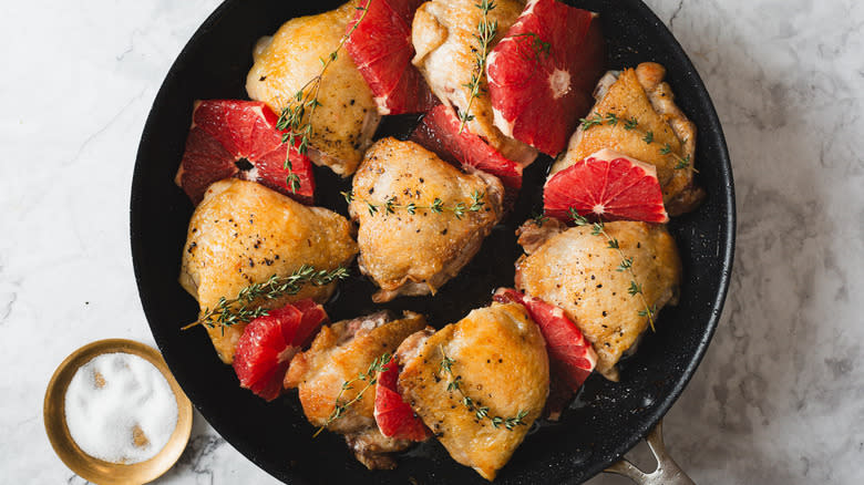 Seared chicken in a pan with grapefruit and thyme