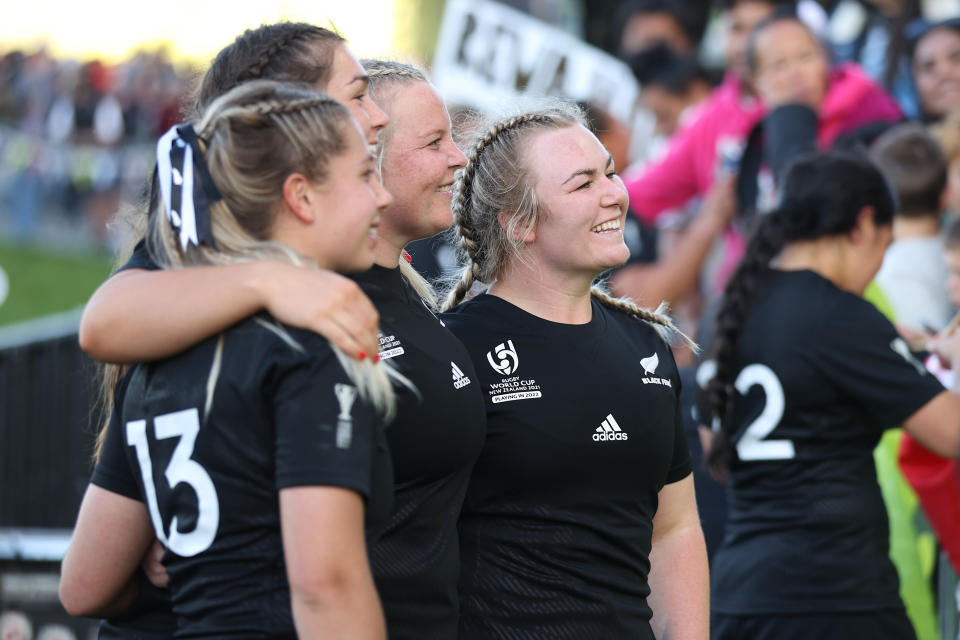 Pictured here, New Zealand women's rugby players stand arm in arms after their World Cup win over Scotland.