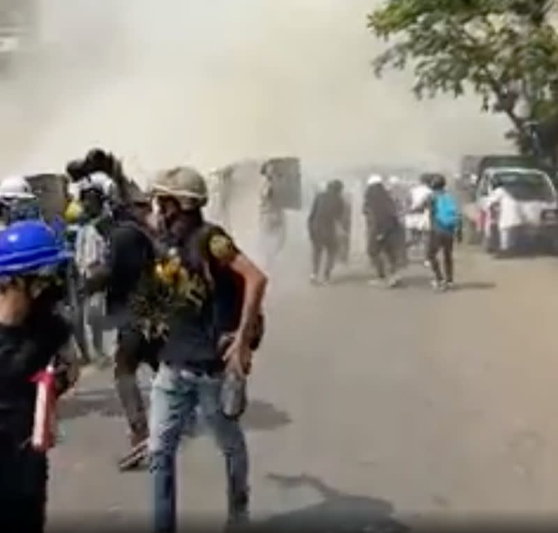 Protesters run away from tear gas in Mandalay