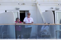 People look out from the Coral Princess cruise ship as it is docked at PortMiami during the new coronavirus outbreak, Saturday, April 4, 2020, in Miami. According to Princess Cruises, disembarkation of guests is expected to take several days due to limited flight availability. Guests requiring shoreside medical care will be prioritized to disembark first. (AP Photo/Lynne Sladky)