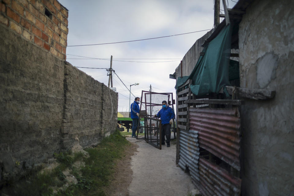 La policía instala cercas para aislar el barrio de Villa Azul después de que más de 50 residentes dieron positivo por coronavirus el lunes 25 de mayo de 2020, según funcionarios de salud del gobierno, en las afueras de Buenos Aires, Argentina. (AP Foto/Natacha Pisarenko)