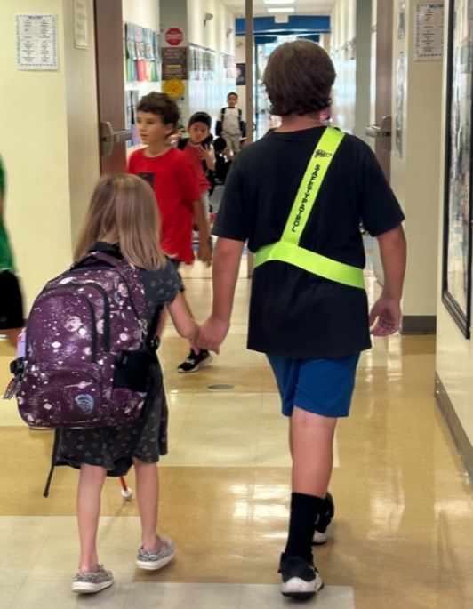 Jesse Brown, at right, walks inside his school in Central Florida. The11-year-old boy died after he suffered a flesh-eating infection after a treadmill injury, his family said.