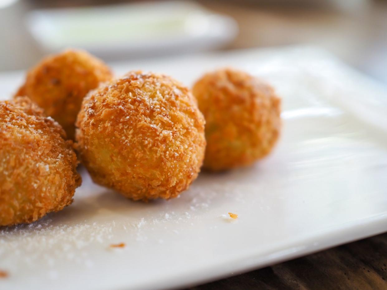 Closeup of potato croquettes on a white plate with a blurred background