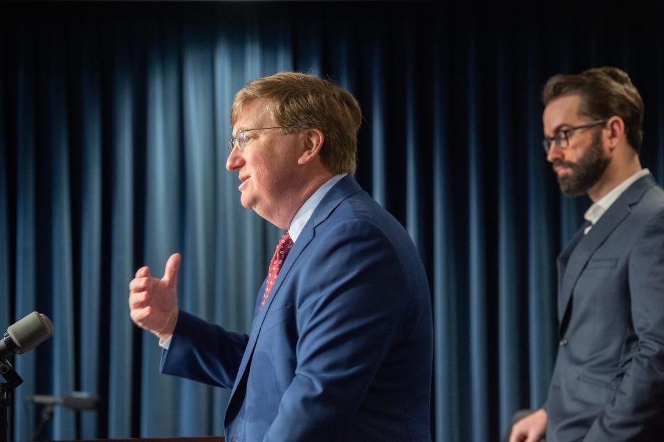 Gov. Tate Reeves, left, answers questions from media in Jackson, Miss., Tuesday, Feb. 28, 2023, after signing HB 1125 baning gender reassignment procedures for Mississippians under the age of 18.  Matt Walsh, with the Daily Wire, a conservative news website and media company, stands at right.