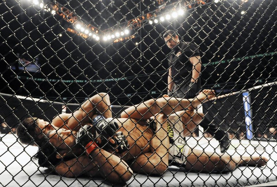 Josh Thomson, back, wrestles Benson Henderson, front, during the main event of the UFC mixed martial arts match in Chicago, Saturday, Jan., 25, 2014. (AP Photo/Paul Beaty)