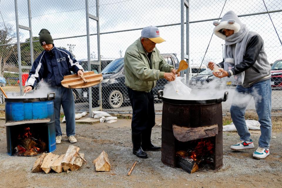 日本石川縣輪島市災民在戶外煮食。路透社