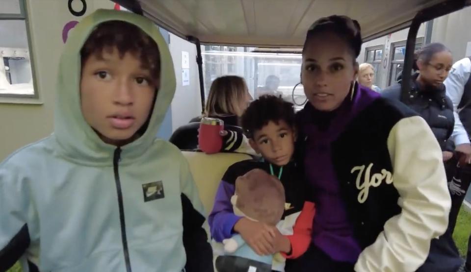 Alicia sits on the back of a golf cart with her two sons