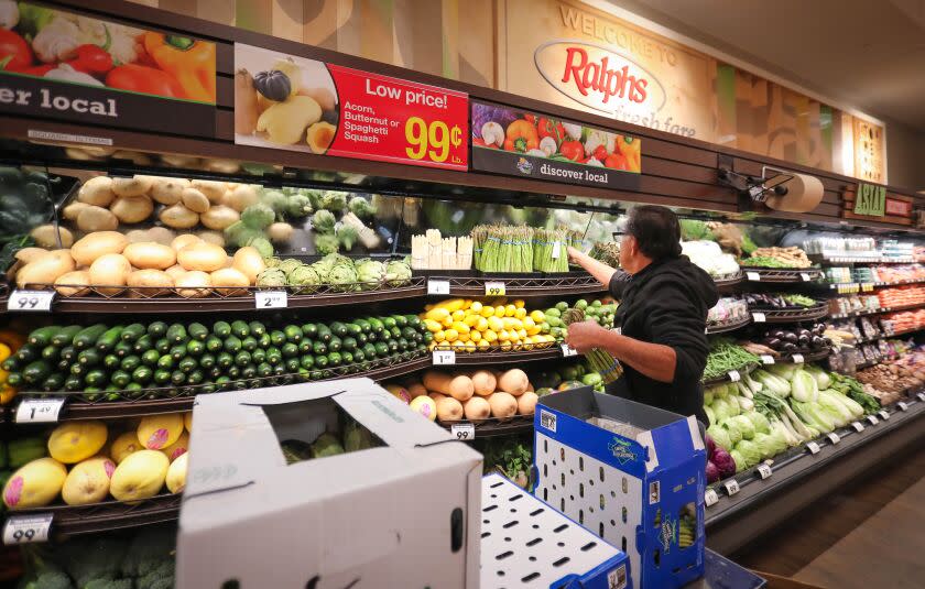 Victor Marcus, a produce clerk at the Ralphs supermarket in the La Jolla Square shopping center, restocks produce at the store, early in the morning, March 19, 2020 in San Diego, California.