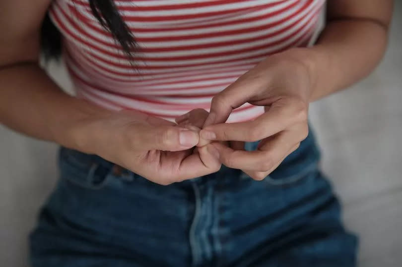 Woman picking her nails.