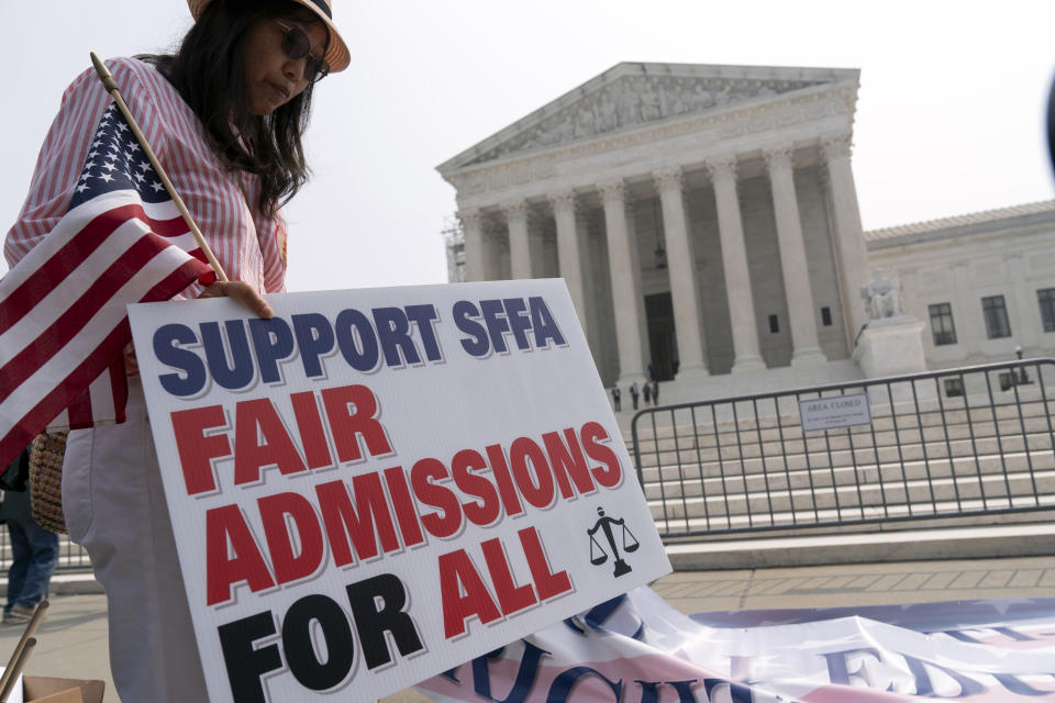 A protester outside the Supreme Court holds a sign reading: Support SFFA, fair admissions for all.