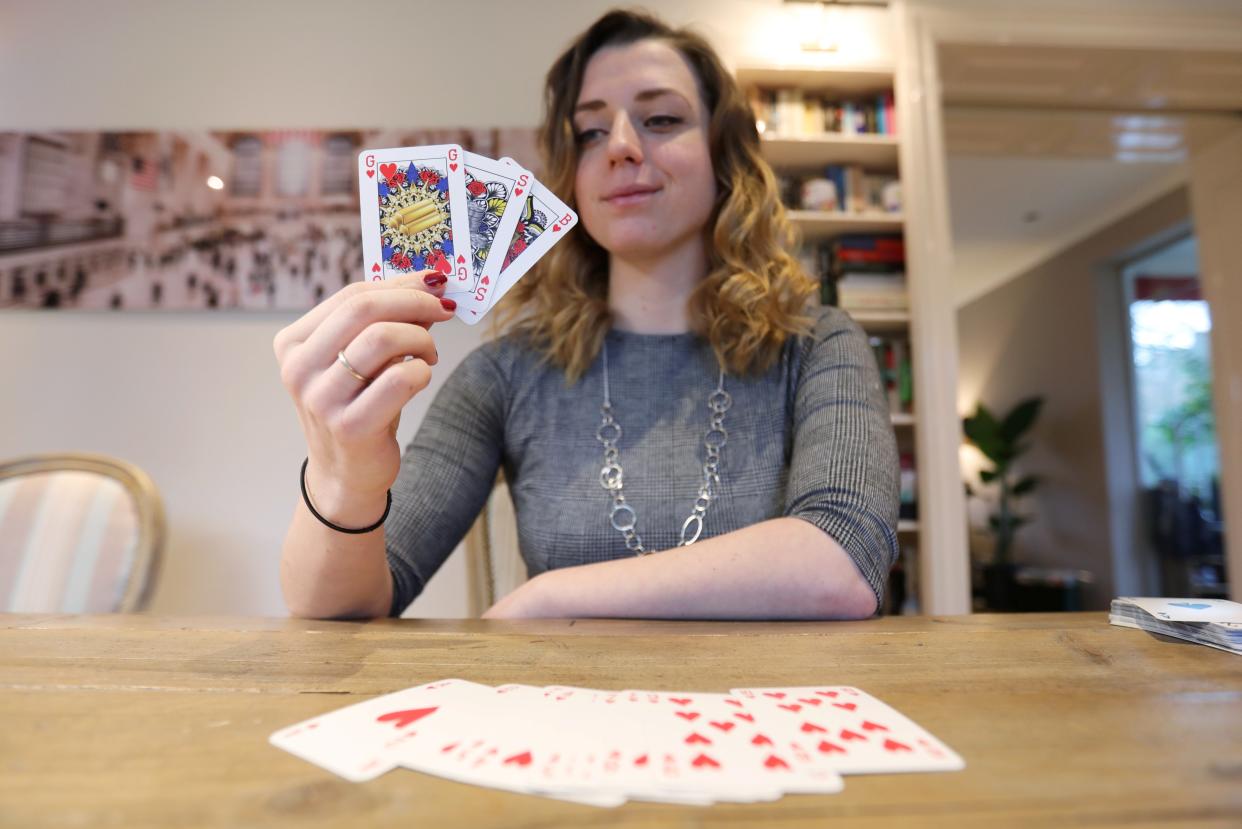 <p>Indy Mellink, 23, shows off the genderless playing cards that she designed </p> (REUTERS)