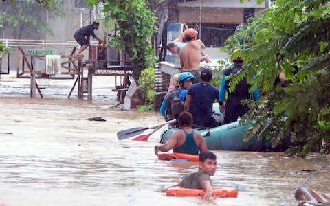 Rescuers evacuate residents from their homes during heavy flooding in Cagayan de Oro city in the Philippine - Credit: Froilan Gallardo/Reuters