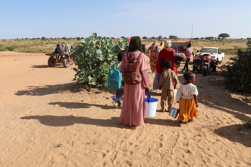 Women look at the border, hoping that their relatives reach Chad to escape death as they wait for them in Chad